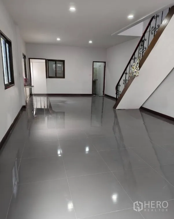 ทาวน์เฮาส์ ขายในPhra Khanong, Bangkok - ห้องนั่งเล่นชั้นล่างกว้าง พื้นกระเบื้องเงา ไฟดาวน์ไลท์ และบันได