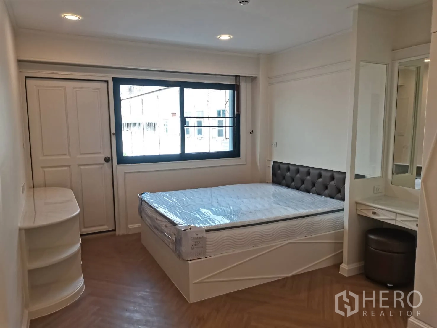 Condominium for rent in Watthana, Bangkok - Bedroom with bed, vanity corner, and large window for natural light.