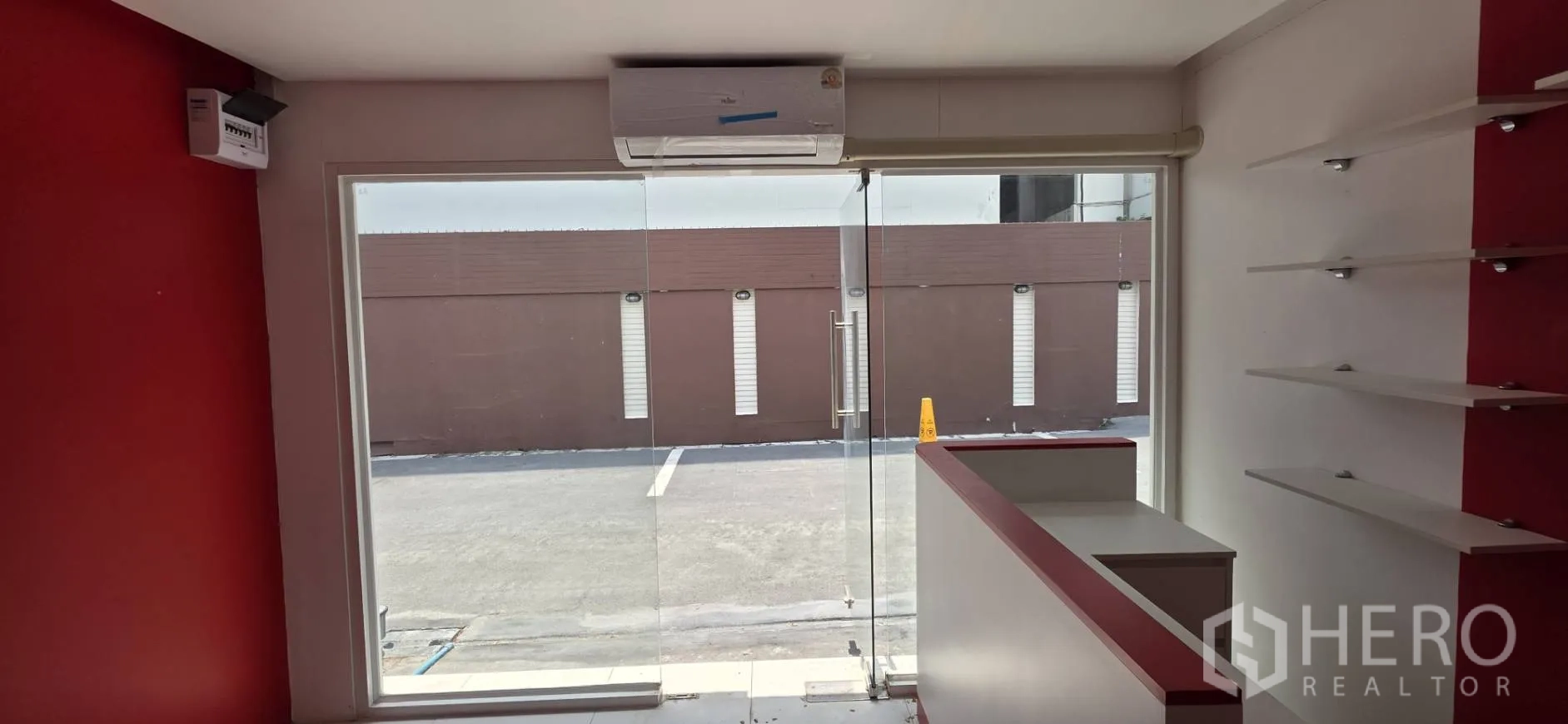 Retail Space for rent in Watthana, Bangkok - View from inside toward the glass entrance with an air conditioner above the doorway.