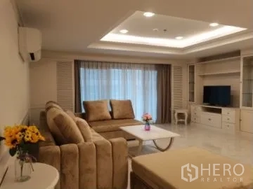 อพาร์ทเมนท์ ให้เช่าในWatthana, Bangkok - ห้องนั่งเล่นมีชั้นวางทีวีและตู้บิลท์อิน โซฟา และหน้าต่างบานใหญ่ติดผ้าม่าน