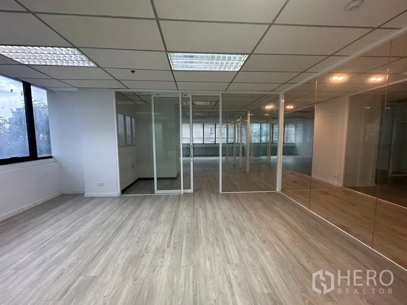 办公空间 出租在Din Daeng, Bangkok - 采光充足的办公角落，玻璃墙与窗户相连。