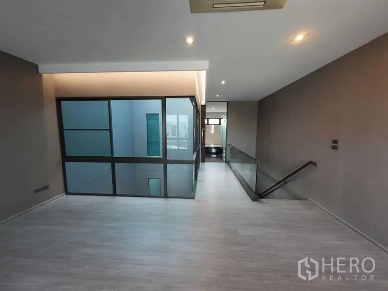 联排别墅 出租或出售在Lat Phrao, Bangkok - 楼层走廊，落地窗与玻璃栏杆，采光充足。