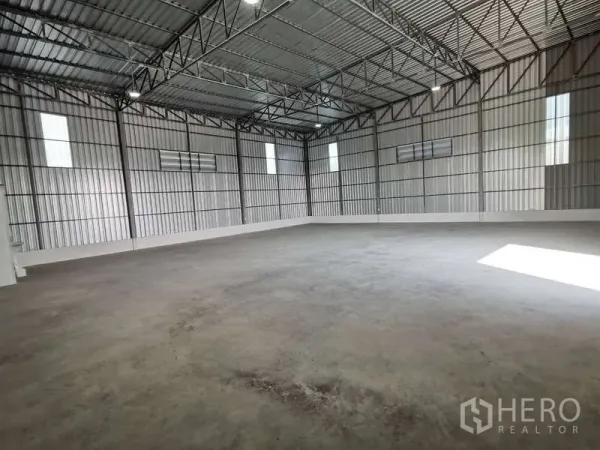 货栈 出租在Prawet, Bangkok - 高挑钢桁架顶与混凝土地面的宽敞仓库内部，带通风窗。