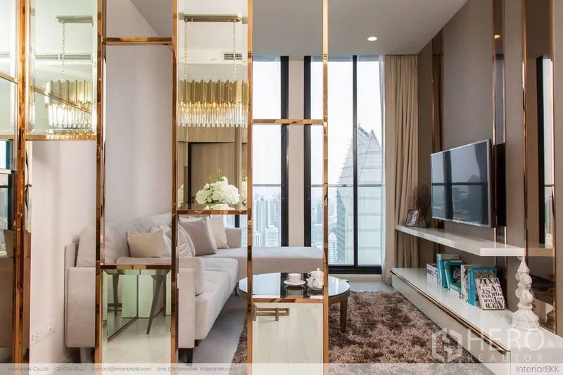 Condominium for rent in Pathum Wan, Bangkok - Living area behind gold-framed glass partition with sofa, TV and city view.