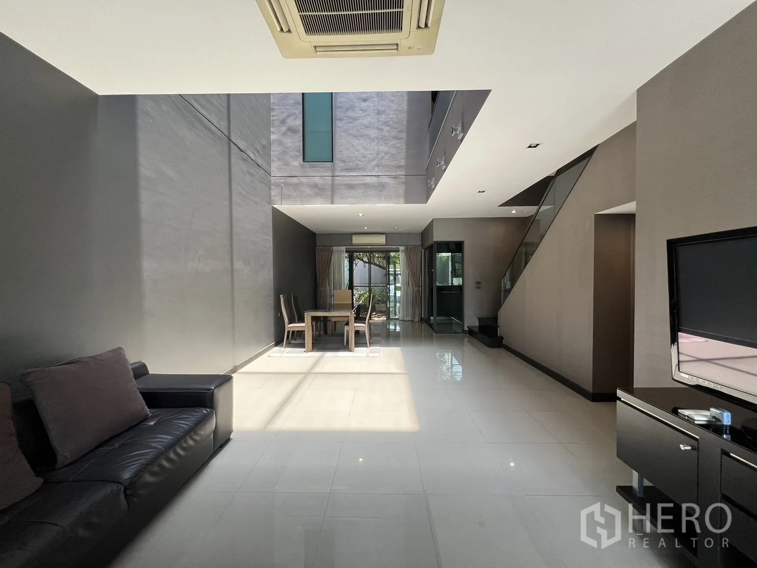 联排别墅 出租在Lat Phrao, Bangkok - 陽光灑入的客廳，展示挑空中庭與後方餐區。