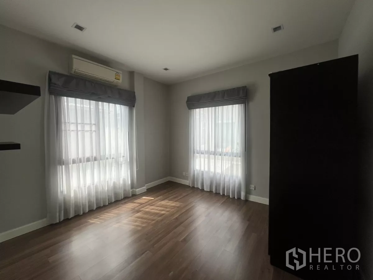 Detached House for sale in Bang Kapi, Bangkok - Bright guest bedroom with dual-aspect windows and sheer curtains.