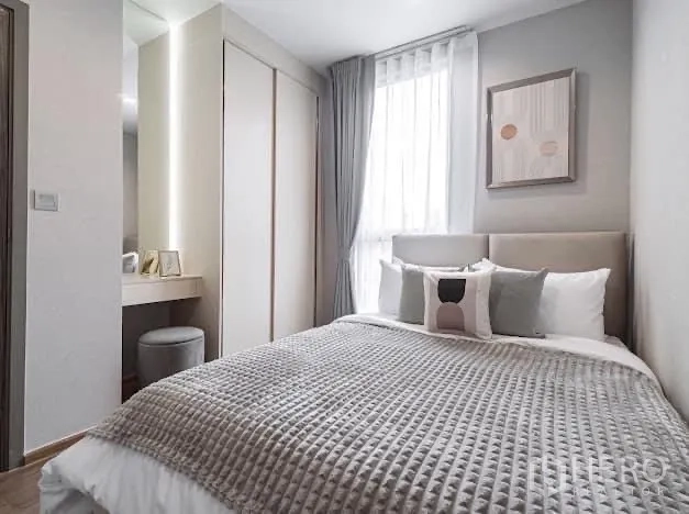 Condominium for rent in Watthana, Bangkok - Second bedroom with built-in wardrobe, vanity and soft gray palette.