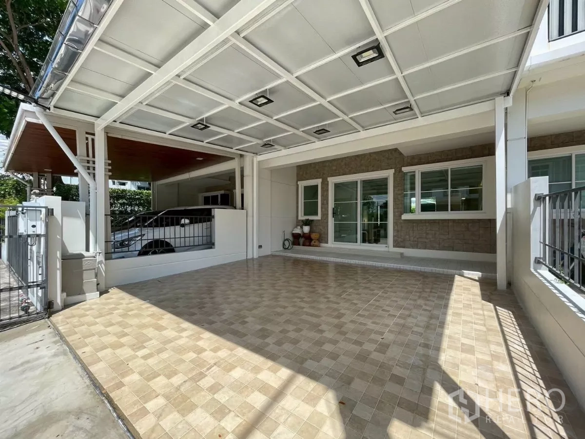 联排别墅 出租在Prawet, Bangkok - 有顶双车位车棚，铺瓷砖地面与推拉窗。