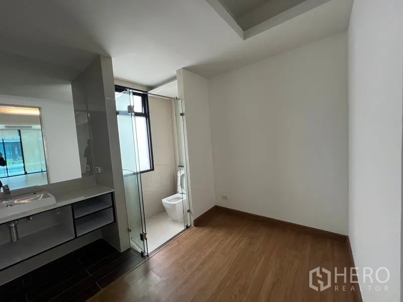 ทาวน์เฮาส์ ให้เช่าหรือขายในKhlong Toei, Bangkok - ห้องนอนพื้นไม้เชื่อมต่อห้องน้ำในตัว ประตูกระจกและเคาน์เตอร์อ่างล้างหน้า