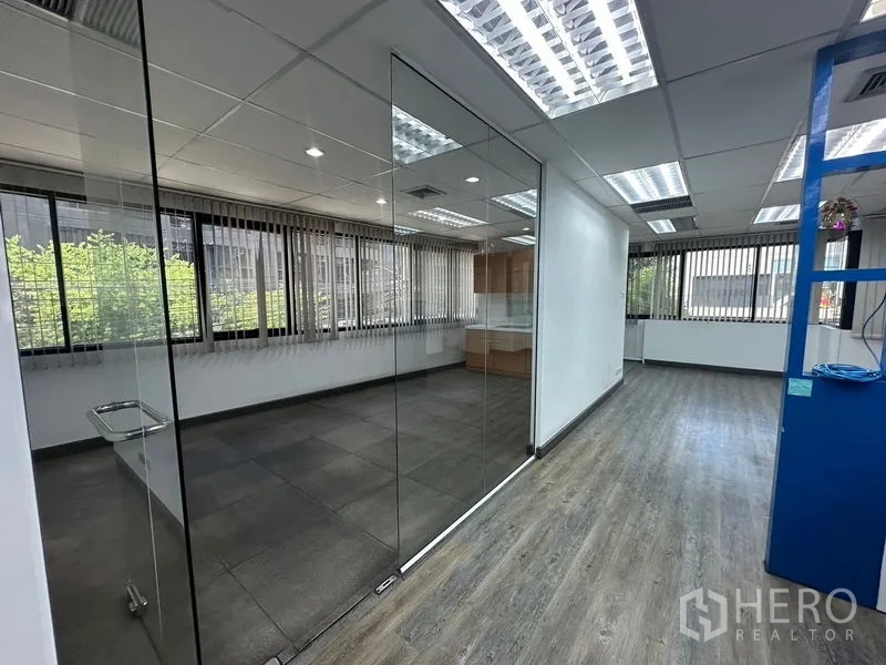 办公空间 出租在Khlong Toei, Bangkok - 通往玻璃会议室的走道，大窗引入自然光