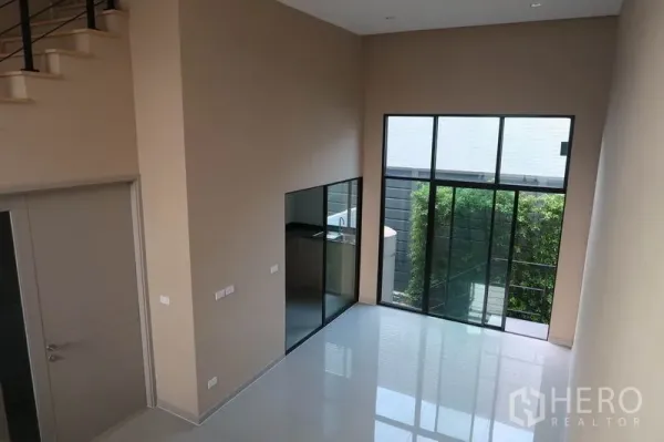 ทาวน์เฮาส์ ให้เช่าในSuan Luang, Bangkok - ห้องรับแขกสว่างพร้อมผนังกระจกเปิดสู่สวนเล็ก และครัวกั้นกระจก