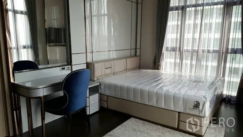 คอนโด ให้เช่าในWatthana, Bangkok - ห้องนอนเตียงใหญ่ โต๊ะเครื่องแป้ง และหน้าต่างเต็มบานพร้อมม่านโปร่ง