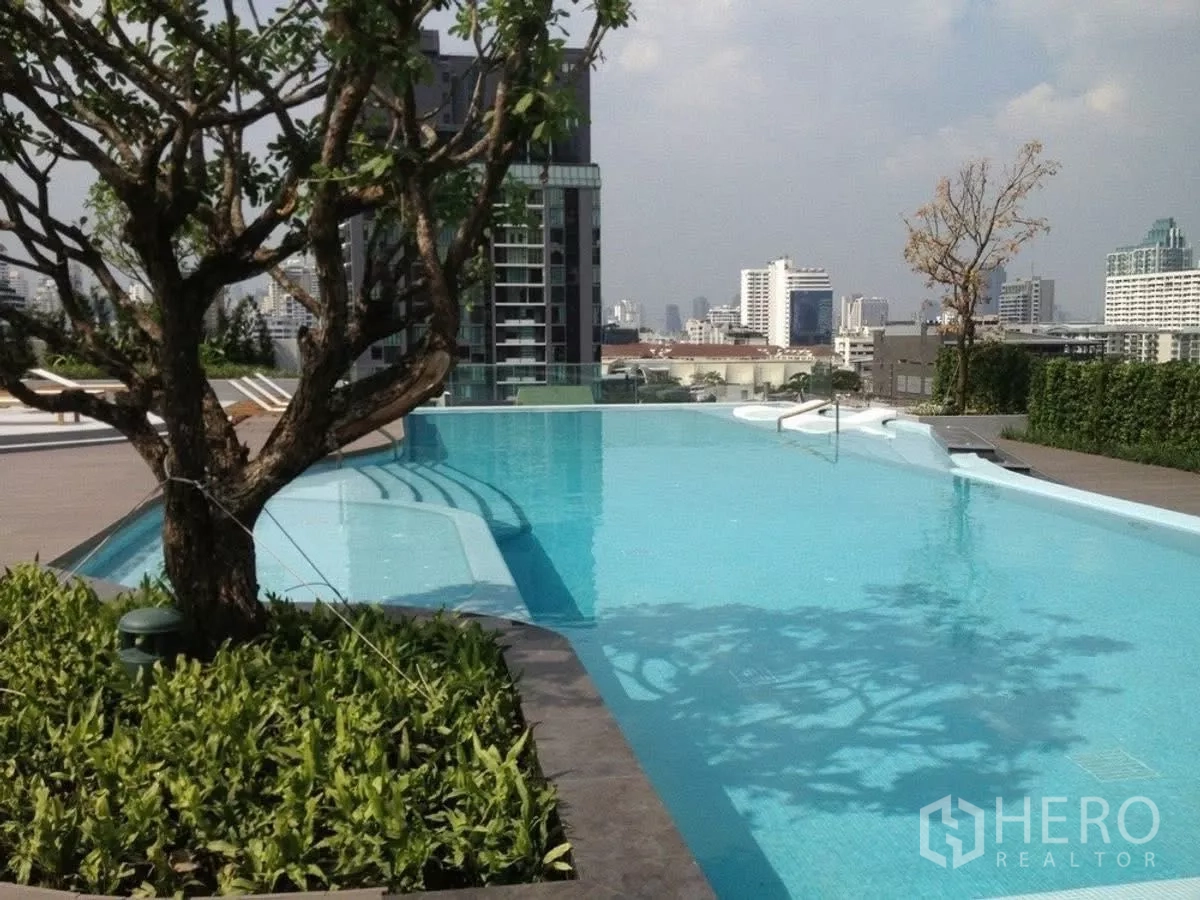 Condominium for rent in Watthana, Bangkok - Rooftop swimming pool with city views and sun loungers.