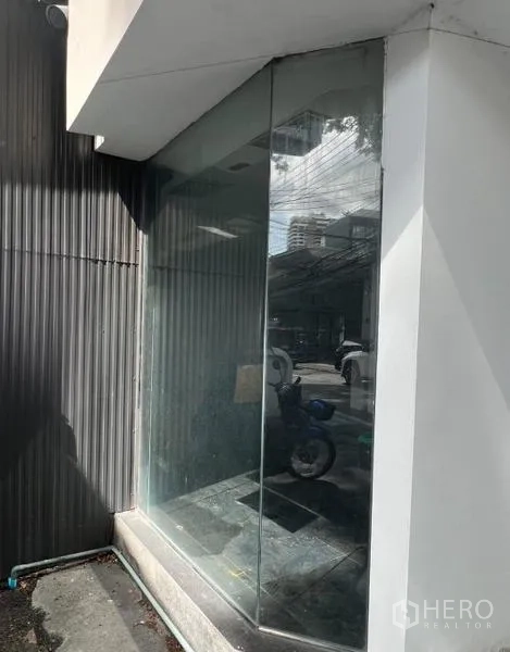 零售空间 出租在Watthana, Bangkok - 临街转角店面，落地玻璃橱窗与白色外立面。
