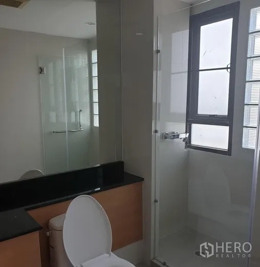 Condominium for rent in Watthana, Bangkok - Secondary bathroom with glass-enclosed shower, window and modern fixtures.
