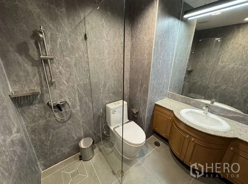 คอนโด ให้เช่า - ห้องน้ำพร้อมฝักบัวกระจก เคาน์เตอร์หินแกรนิตโค้ง และกระจกบานใหญ่