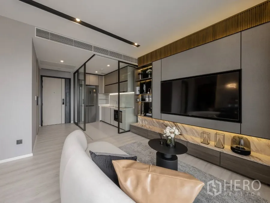 公寓 出售在Ratchathewi, Bangkok - 现代客厅，内置电视墙、玻璃隔断厨房与浅色木地板的曼谷公寓。