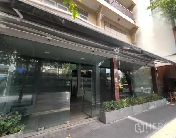 อาคารพาณิชย์ ให้เช่าในWatthana, Bangkok - ทางเข้าใต้กันสาดพร้อมประตูกระจกใสและกระบะต้นไม้ริมทางเท้า.