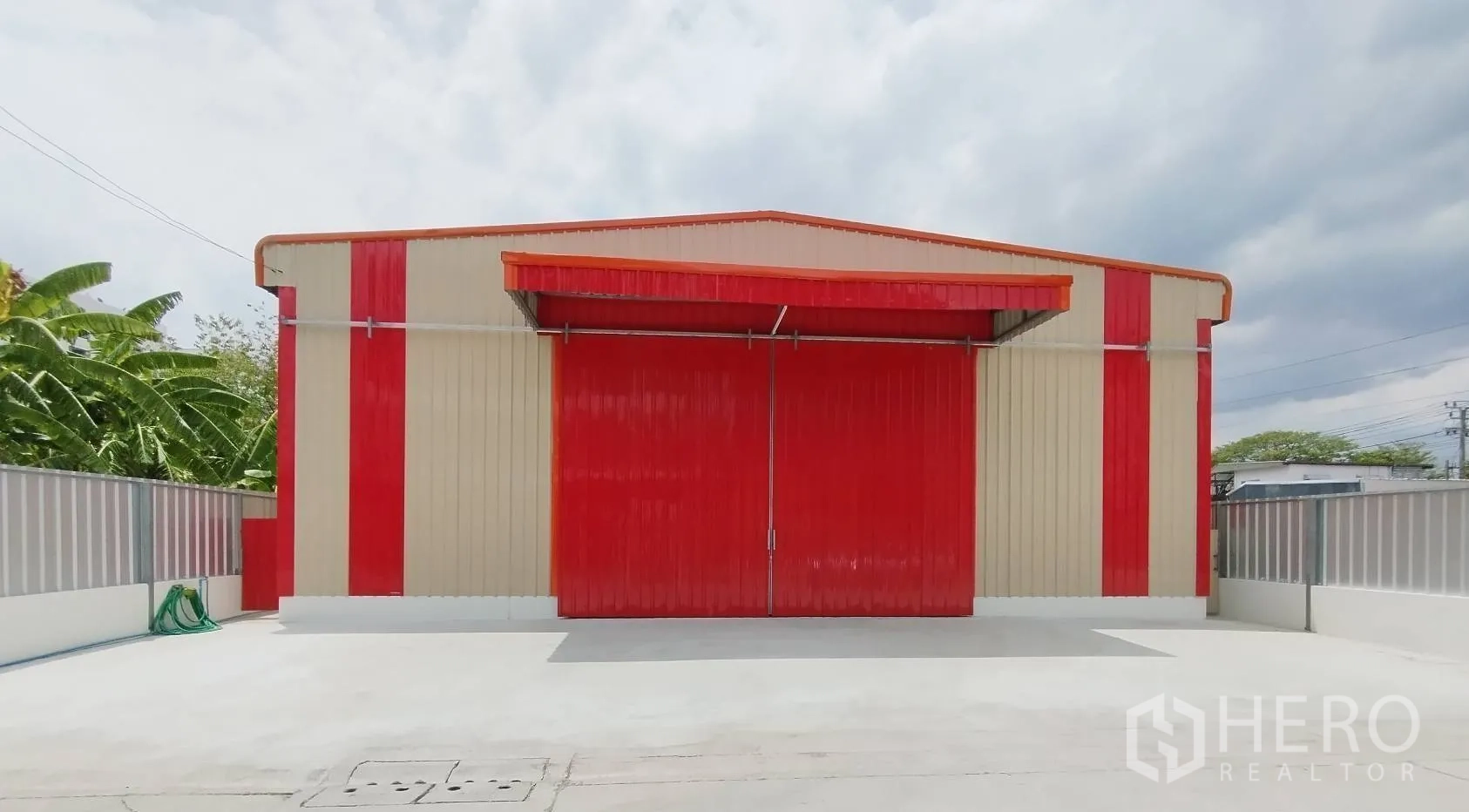 仓库 for rent in Bang Khen, Bangkok - 仓库正立面近景，红色大门关闭，米红相间金属包板与围栏。