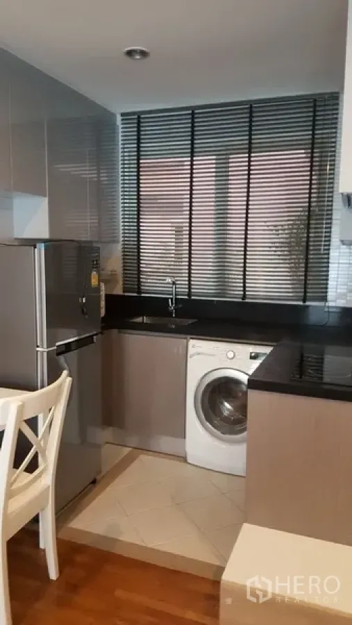 คอนโด ให้เช่าในWatthana, Bangkok - ครัวขนาดกะทัดรัด เคาน์เตอร์สีดำ มู่ลี่หน้าต่าง ตู้เย็นสเตนเลส และเครื่องซักผ้าฝาหน้า