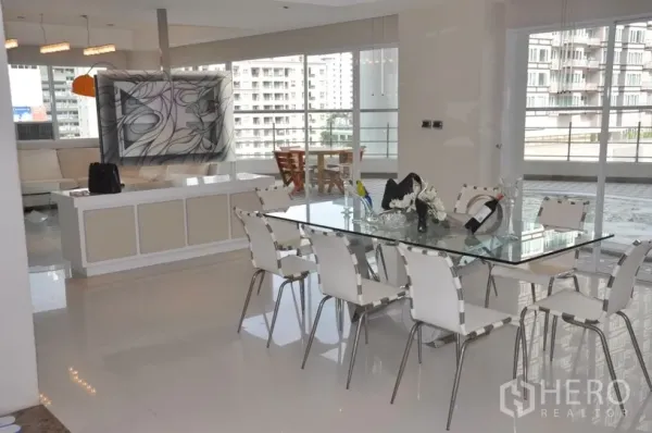 คอนโด ให้เช่าในKhlong Toei, Bangkok - มุมรับประทานอาหารสมัยใหม่ โต๊ะกระจกที่นั่งแปดคน หน้าต่างสูงจรดเพดาน และทางออกสู่ระเบียงรอบห้อง
