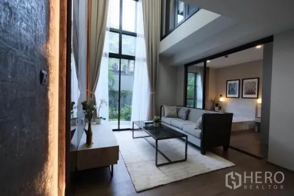 คอนโด ให้เช่าในPathum Wan, Bangkok - ห้องรับแขกสว่างด้วยกระจกสูงจากพื้นจรดเพดาน มองเห็นสวนในคอนโดดูเพล็กซ์