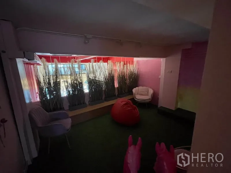 店屋 出租在Ratchathewi, Bangkok - 窗边休闲角，种植箱、懒人沙发与草坪地面。