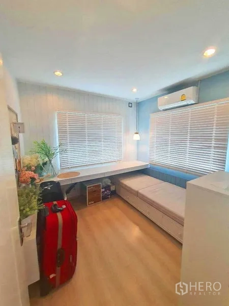 Detached House for sale in Samut Prakan - Bright study or guest room with corner desk, daybed and large windows.