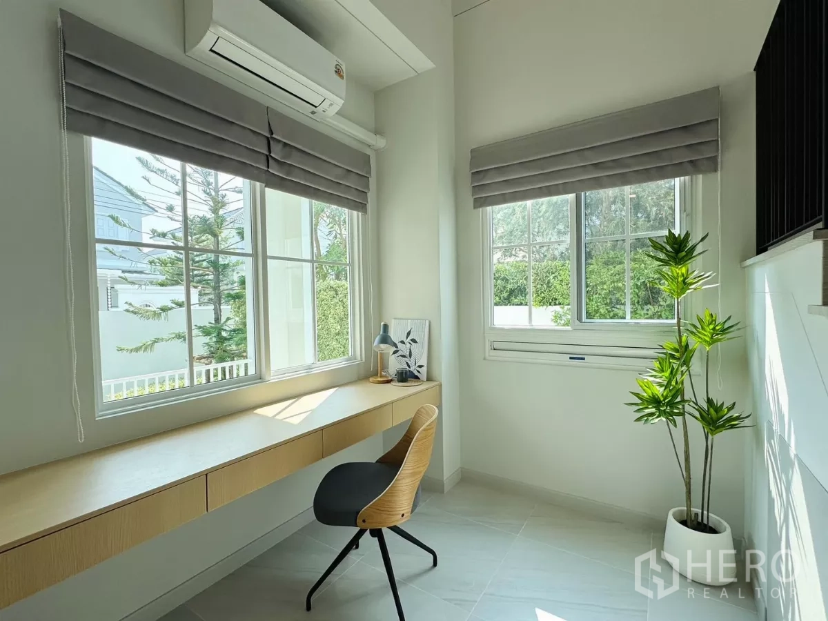 Detached House for rent in Bang Phli, Samut Prakan - Bright home office with long built-in desk, two windows and a potted plant.