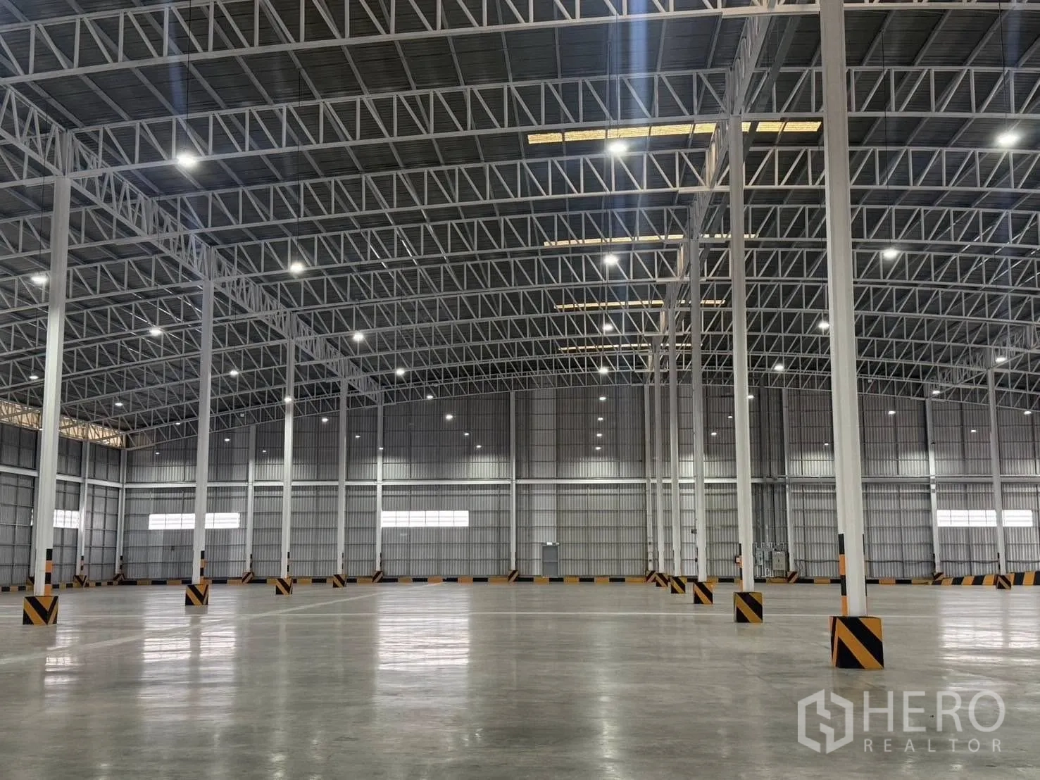 Factory for rent in Si Racha, Chon Buri - Close view of steel columns, braced roof trusses, and polished floor.