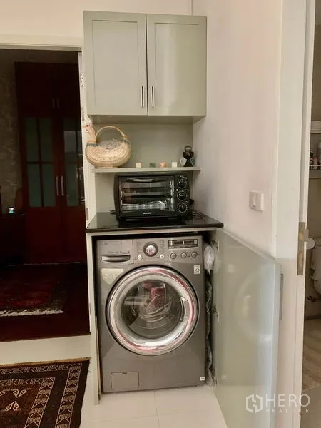 คอนโด ให้เช่าในBang Kapi, Bangkok - มุมซักล้างกะทัดรัด เครื่องซักผ้าฝาหน้า ตู้แขวน และเครื่องใช้บนเคาน์เตอร์