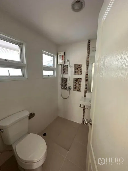 独立式住宅 出售在Prawet, Bangkok - 明亮浴室，马桶、淋浴区与热水器。