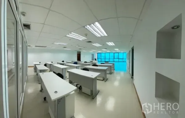 办公空间 出租 - 开敞式办公区，多排工位，明亮照明与玻璃隔断。