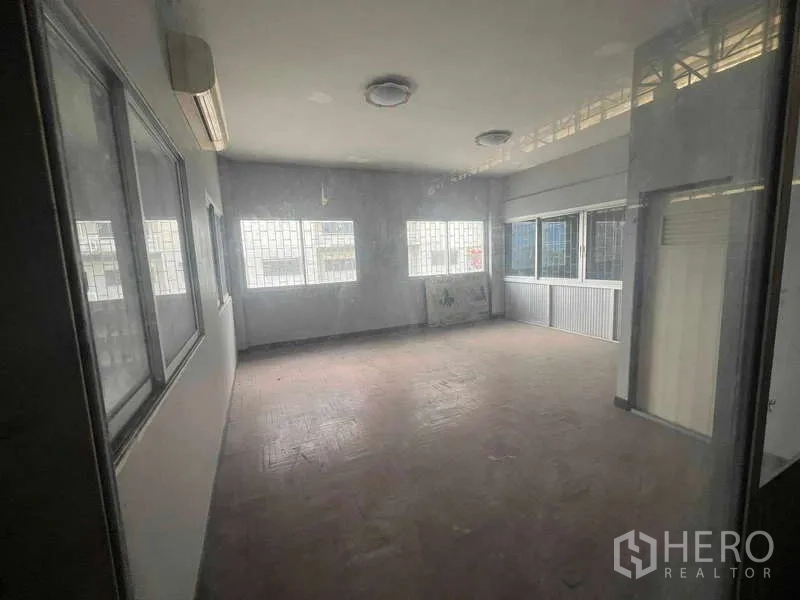 Warehouse for rent in Lam Luk Ka, Pathum Thani - Bright office room inside the warehouse with barred windows and an air conditioner.