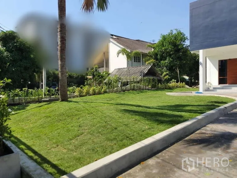 独立式住宅 出租在Phra Khanong, Bangkok - 前庭花园，整齐草坪、棕榈树与现代外观。