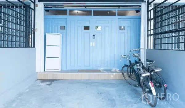 ทาวน์เฮาส์ ให้เช่าในKhlong Toei, Bangkok - ที่จอดรถในร่มพร้อมประตูนิรภัยสีฟ้าพาสเทล และจักรยานหน้าทาวน์เฮ้าส์