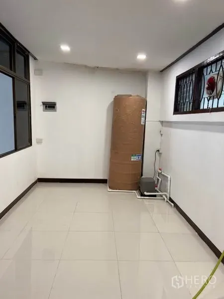 ทาวน์เฮาส์ ให้เช่าในKhlong Toei, Bangkok - มุมยูทิลิตี้พื้นกระเบื้องสีขาว มีแทงค์น้ำและปั๊มน้ำข้างหน้าต่างเหล็กดัด