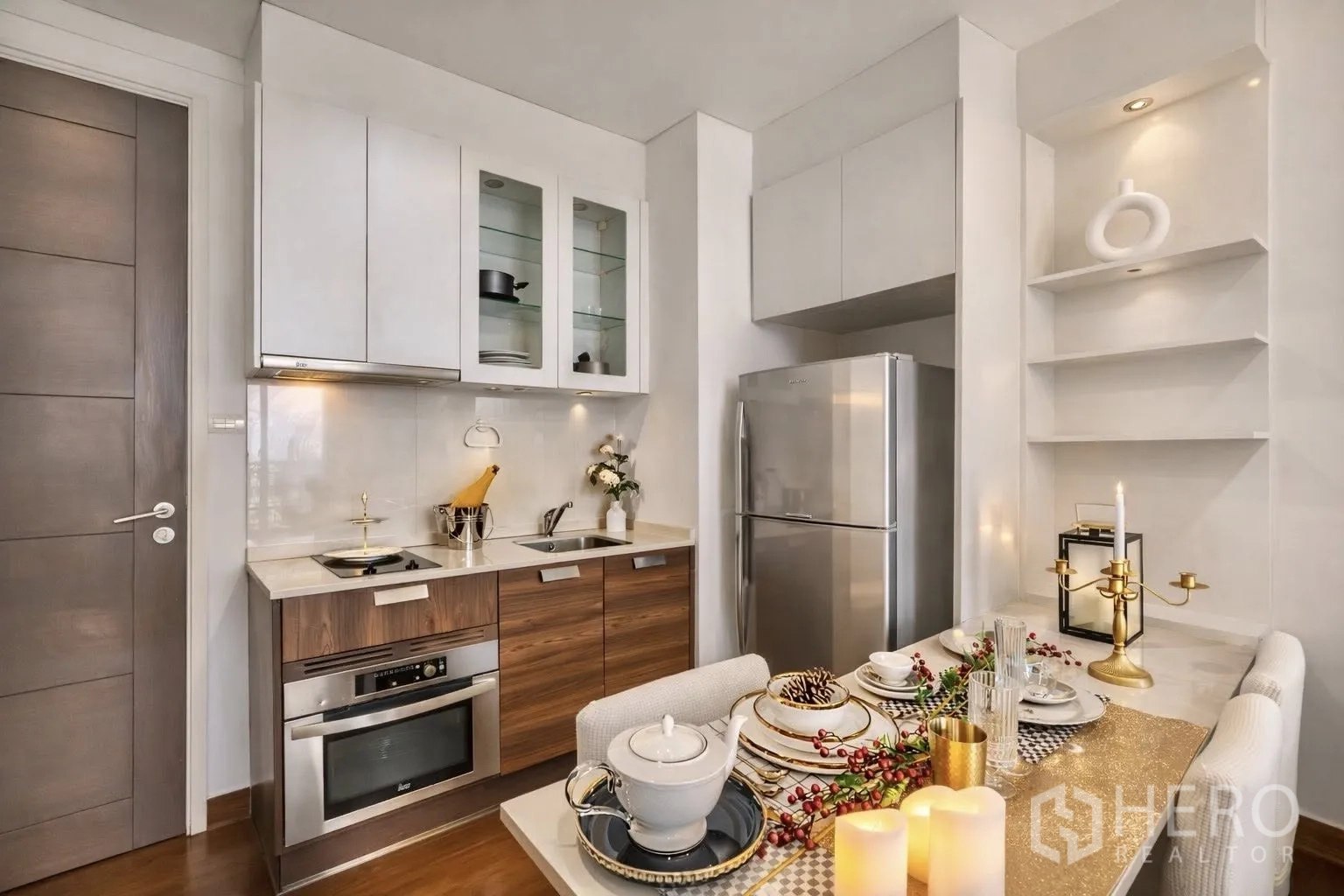 Condominium for rent or sale in Watthana, Bangkok - Modern kitchenette with stove, oven, sink, and full-size refrigerator.