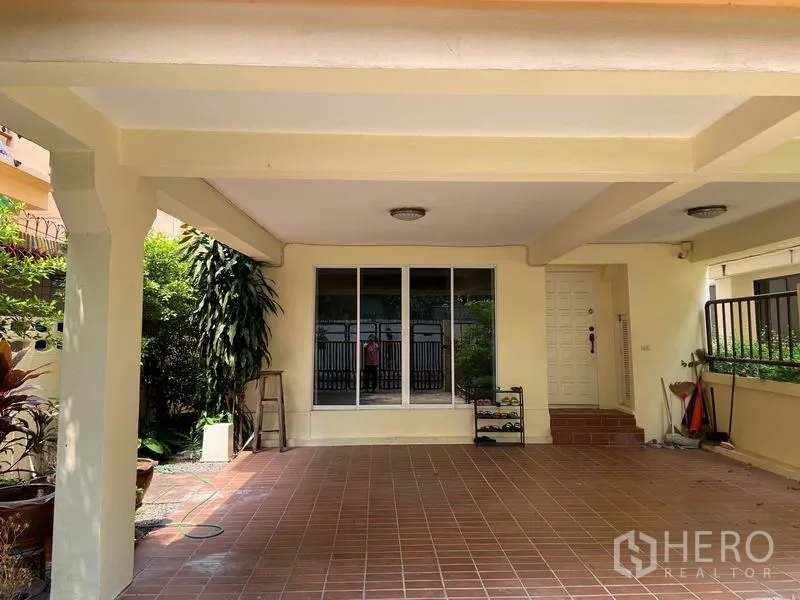 บ้าน ให้เช่าในWatthana, Bangkok - ที่จอดรถในร่ม พื้นกระเบื้อง เสากั้น พร้อมประตูบานเลื่อนและสวนข้างบ้าน