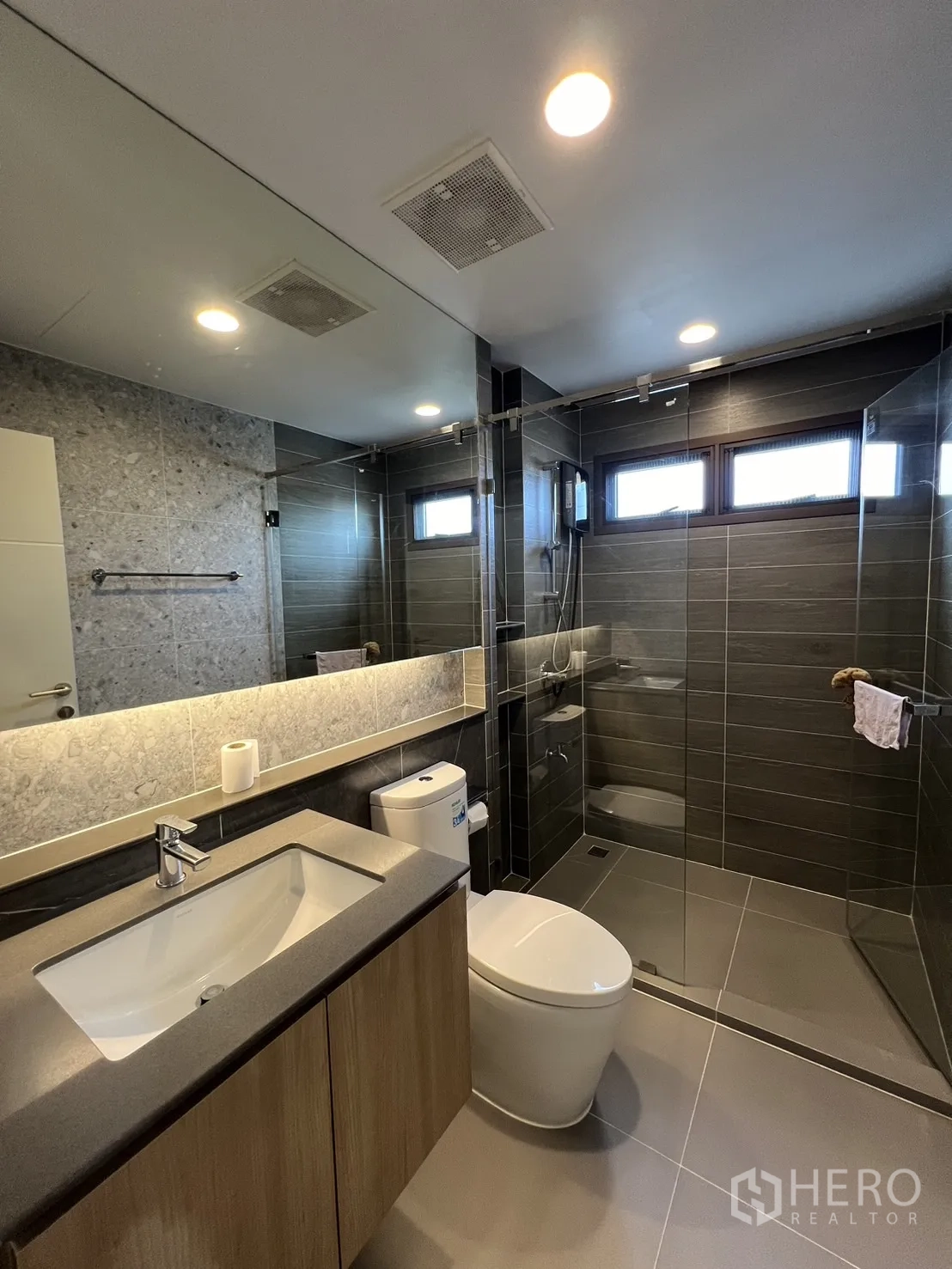 Detached House for rent or sale in Bang Kapi, Bangkok - Bathroom with stone-effect wall, vanity and glass shower enclosure