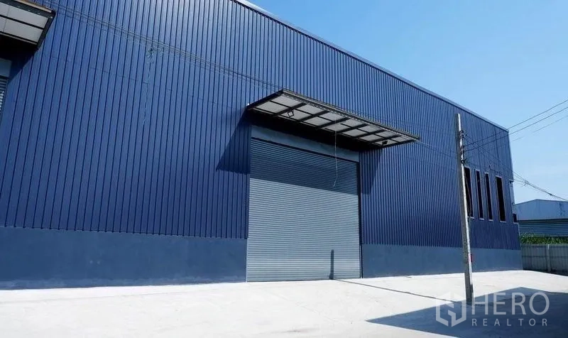 货栈 出租在Bueng Kum, Bangkok - 仓库立面配大型卷帘门和装卸雨棚。