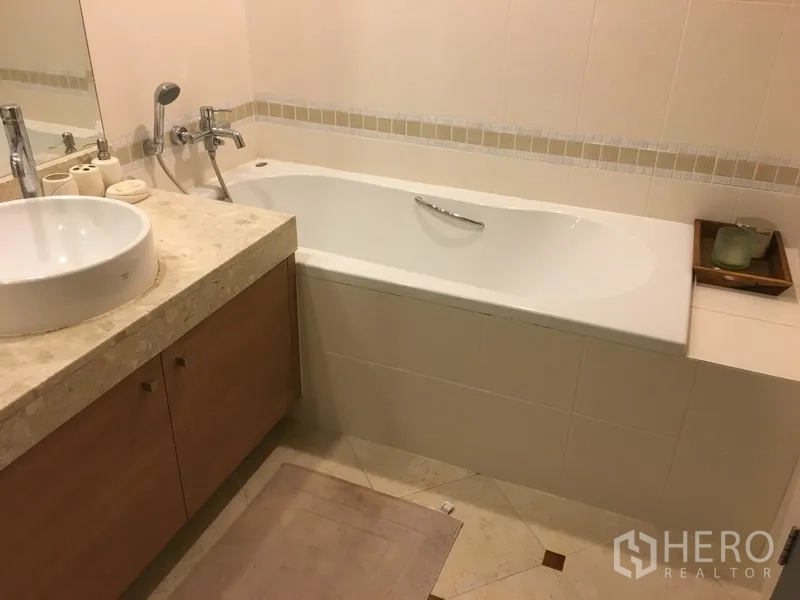 公寓 出售在Khlong Toei, Bangkok - 浴室配长形浴缸与石质台面盆柜。