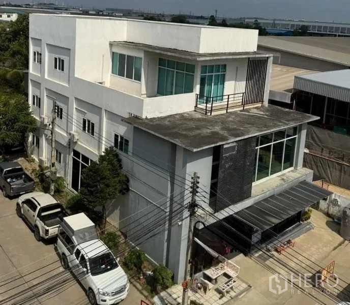 Warehouse for rent or sale in Chon Buri - Aerial view of the multi-level warehouse with rooftop terrace in an industrial neighborhood.