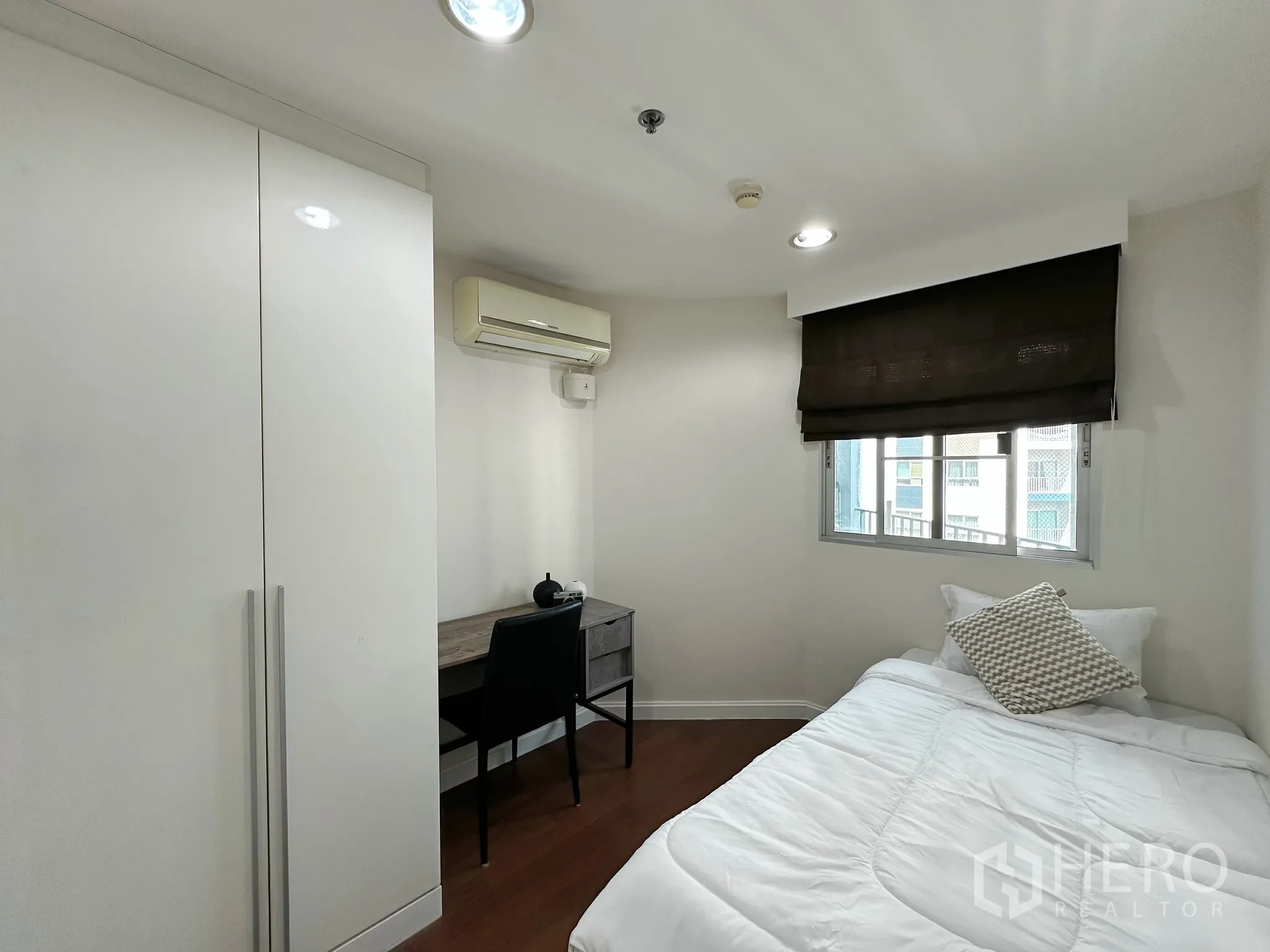 คอนโด for sale in Huai Khwang, Bangkok - ห้องนอนเล็กพร้อมเตียงเดี่ยว โต๊ะทำงาน ตู้เสื้อผ้า และเครื่องปรับอากาศ.