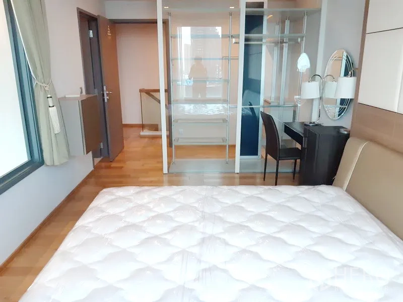 คอนโด ให้เช่าในKhlong Toei, Bangkok - มุมห้องนอนหลักเห็นตู้เสื้อผ้าบานกระจกแบบวอล์กอินและโต๊ะเครื่องแป้งข้างหน้าต่าง