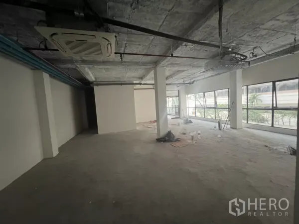 零售空间 出租在Watthana, Bangkok - 开放式零售楼层，带嵌入式空调、外露管线与长排侧窗。