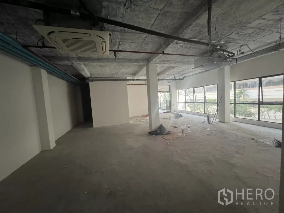 零售空间 出租在Watthana, Bangkok - 开放式零售楼层，带嵌入式空调、外露管线与长排侧窗。