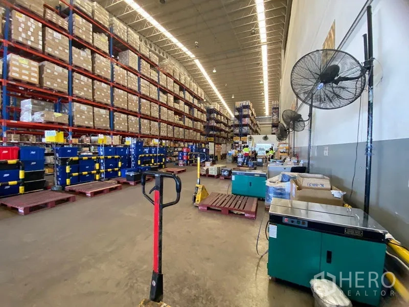 Warehouse for rent in Bang Phli, Samut Prakan - Warehouse aisle featuring tall storage racks, pallets and material-handling equipment.