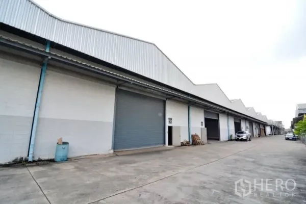 货栈 出租在Phra Pradaeng, Samut Prakan - 仓库外立面，卷闸门与宽阔通道，适合卡车出入。