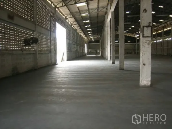 Warehouse for rent in Min Buri, Bangkok - Spacious warehouse interior with high steel roof, concrete flooring, skylights and support columns in Min Buri, Bangkok.